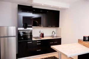 a kitchen with black cabinets and a stainless steel refrigerator at Florina Sky Loft in Florina +12 photos