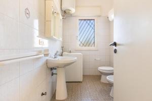 Baño blanco con lavabo y aseo en Villino Dalila by BarbarHouse, en Torre Ovo