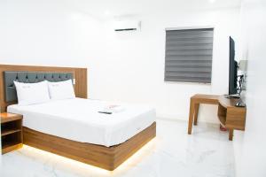 Maganda hotel في انجلس: غرفة نوم بسرير ومكتب وتلفزيون