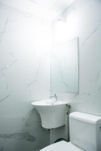 een witte badkamer met een wastafel en een toilet bij Maganda hotel in Angeles