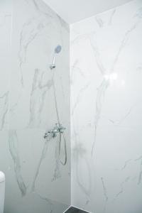 uma casa de banho com chuveiro e paredes em mármore branco em Maganda hotel em Angeles