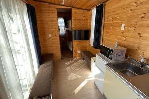 uma pequena cozinha com um lavatório e um micro-ondas em 富士山下Trailer House-B em Narusawa