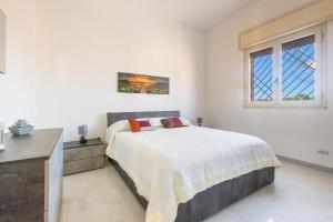 1 dormitorio con cama, escritorio y ventana en Villino Dalila by BarbarHouse, en Torre Ovo