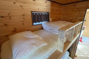 two bunk beds in a wooden cabin with a window at 富士山下Trailer House-B in Narusawa