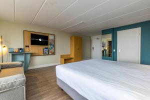 1 dormitorio con 1 cama grande y TV en Fletcher Hotel Restaurant Loosdrecht-Amsterdam, en Loosdrecht