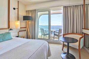 een hotelkamer met een bed en uitzicht op de oceaan bij Atlantic Hôtel & Spa in Les Sables-dʼOlonne