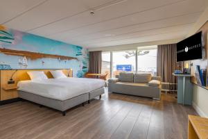 a bedroom with a bed and a couch and a tv at Fletcher Hotel Restaurant Loosdrecht-Amsterdam in Loosdrecht