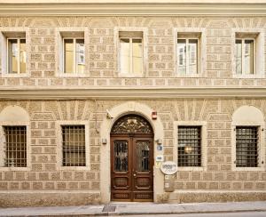 un grande edificio in pietra con una porta in legno di URBANAUTS STUDIOS Minelli a Trieste