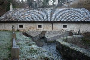 un antiguo edificio de piedra con un techo encima en Casa nel borgo nella natura en Pettorano sul Gizio