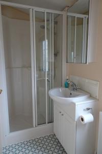 a white bathroom with a shower and a sink at Asgard in Big Sand