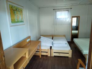 Habitación pequeña con 2 camas y mesa. en Chatová osada U Jaryna en Doksy