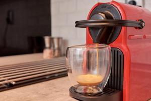 a red coffee machine with a cup of coffee at Florina Sky Loft in Florina