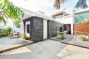 a courtyard of a home with a black brick wall at Stars By The Bay & BBQ Grill by StayVista in Dabolim