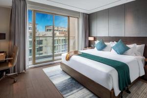 1 dormitorio con cama grande y ventana grande en Oakwood Premier Phnom Penh en Phnom Penh