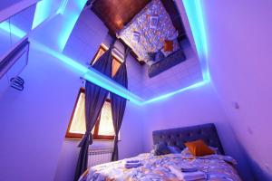 a bedroom with a bed with a blue lighting at Hedonist Spa Apartment in Sarajevo