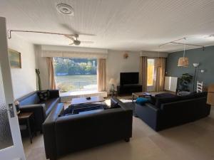 een woonkamer met 2 banken en een televisie bij Un Havre de paix en bordure de la Dordogne in Lalinde