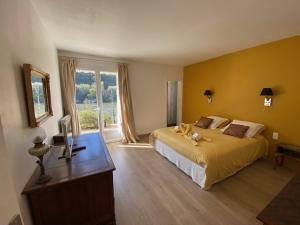 een slaapkamer met een groot bed en een raam bij Un Havre de paix en bordure de la Dordogne in Lalinde