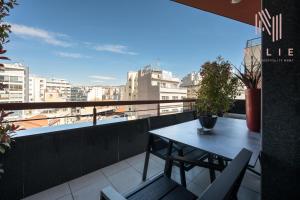 a table on a balcony with a view of a city at Green Tulip, Nilie Hospitality MGMT in Thessaloniki