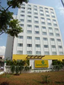un gran edificio blanco con una señal amarilla delante en Lemon Tree Hotel Chennai, en Chennai