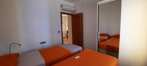 mały pokój z 2 łóżkami i lustrem w obiekcie POS, Apartamento pesquero en primera linea w mieście Era de Soler