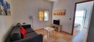 salon z kanapą i telewizorem w obiekcie POS, Apartamento pesquero en primera linea w mieście Era de Soler