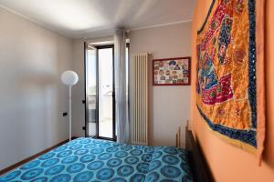 een slaapkamer met een bed en een quilt aan de muur bij Bed&Business Nick Bellezza-San Siro Stadio-Rho Fiera in Settimo Milanese