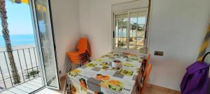 una sala da pranzo con tavolo e vista sull'oceano di POS, Apartamento pesquero en primera linea a Era de Soler