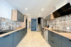 a large kitchen with blue cabinets and tile walls at Leon's house in Saint Aygulf in Fréjus