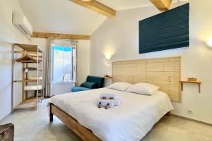 een slaapkamer met een groot bed met een teddybeer erop bij Leon's house in Saint Aygulf in Fréjus