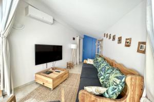 een woonkamer met een bank en een flatscreen-tv bij Leon's house in Saint Aygulf in Fréjus