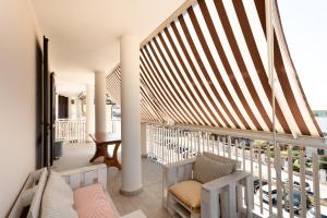 een balkon met 2 stoelen en een houten trapleuning bij Bed&Business Nick Bellezza-San Siro Stadio-Rho Fiera in Settimo Milanese