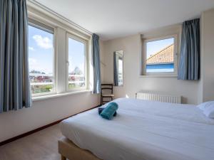 ein Schlafzimmer mit einem Bett und zwei Fenstern in der Unterkunft Maxime 205 - Kustpark Village Scaldia in Hoofdplaat
