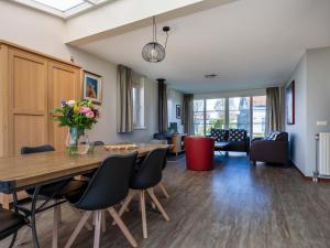 a dining room and living room with a table and chairs at Maxime 205 - Kustpark Village Scaldia in Hoofdplaat