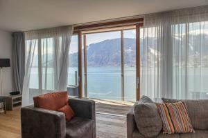 - un salon avec un canapé et une grande fenêtre dans l'établissement Residence Bellevue by Alpin Rentals, à Zell am See