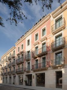 um edifício de apartamentos com varandas numa rua em Elke Spa Hotel Superior em Sant Feliu de Guíxols