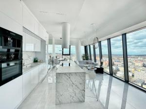a white kitchen with a view of a city at Apartament White Sky 20 Hanza Tower- Free parking in Szczecin