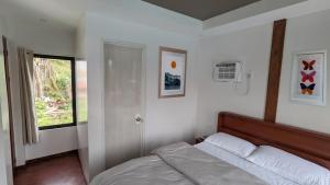 a bedroom with a bed and a window in it at Bakawan Hideaway Resort and Restaurant in Tomas Oppus