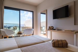 a hotel room with a bed and a large window at Hotel California Garden in Salou