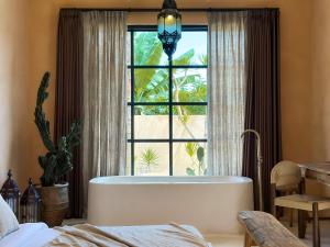 a bathroom with a large tub in front of a window at Villa Mahuwa in Canggu