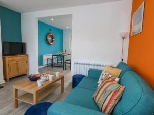 a living room with a blue couch and a table at Lagoon View in Weymouth