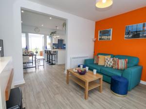 a living room with a blue couch and an orange wall at Lagoon View in Weymouth