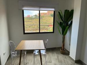 een tafel en stoelen in een kamer met een raam bij New 2023 full equipped stylish digi in Los Realejos