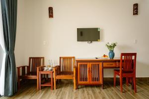 a room with three chairs and a desk with a tv at Windbell Villa Hoi An in Hoi An