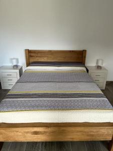 1 dormitorio con 1 cama de madera y 2 mesitas de noche en New 2023 full equipped stylish digi, en Los Realejos