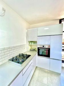a kitchen with white cabinets and a stove top oven at Apartment Beauty in Bat Yam