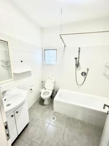 a bathroom with a tub and a toilet and a sink at Apartment Beauty in Bat Yam