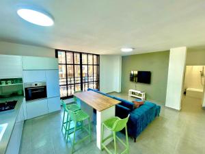 a kitchen and living room with a blue couch and a table at GK apartment Beauty in Bat Yam
