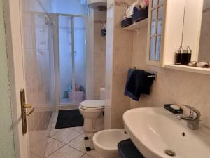 a bathroom with a toilet and a sink and a shower at Aurora 2 in Lido di Pomposa +16 photos