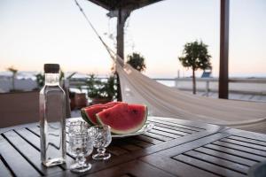 una rebanada de sandía en una mesa con una botella y vasos en Diotima - Astonishing seaview, en La Canea