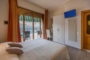 a bedroom with a large bed and a large window at Hotel Nettuno in Brenzone sul Garda
